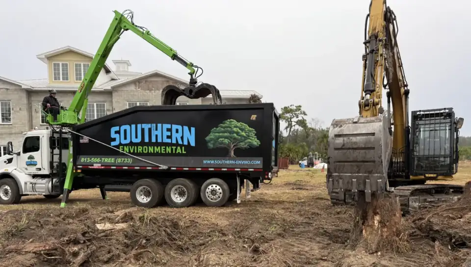 Southern Environmental Group excavator and grapple truck removing stumps for site prep in Tampa Bay , Atlas crane truck and excavator clearing land for residential construction site development